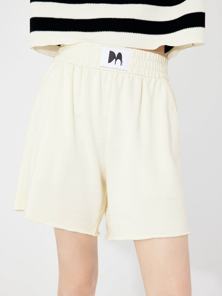 MO&Co. Women's Elastic Waist Cotton Casual Sweatpants Shorts in Beige features a comfortable fit and slant pockets, these shorts feature a flattering, athletic silhouette that's ideal for any activity. Plus, the elastic waist with logo patch details add a stylish touch.