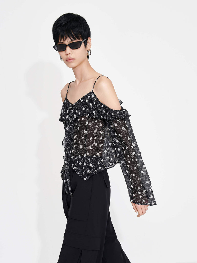 This MO&Co. Cut Shoulder Printed Top in Black is crafted from 100% recyclable fibers, making it a stylish and sustainable choice. Show off your fashion-forward style with off-shoulder trumpet sleeves, a floral and polka dot print, and pleated trim detailing on the front. Elevate your wardrobe with this statement piece!
