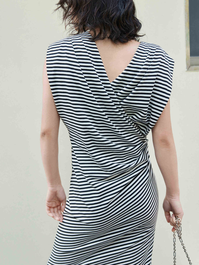 Be effortlessly elegant in this MO&Co. Gathered Waist Stripe dress in Classic Black and White. It features a timeless black and white striped pattern, a pleated gathering at the waist, a cross design at the back, and wide shoulders for a flattering silhouette.