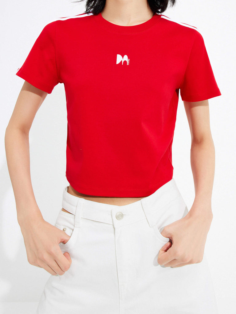 MO&Co.'s cropped logo print T-shirt in Red for women. It offers a slim fit, crewneck, short sleeves, and an M pattern print at the chest. Plus, it features contrasting trim details.