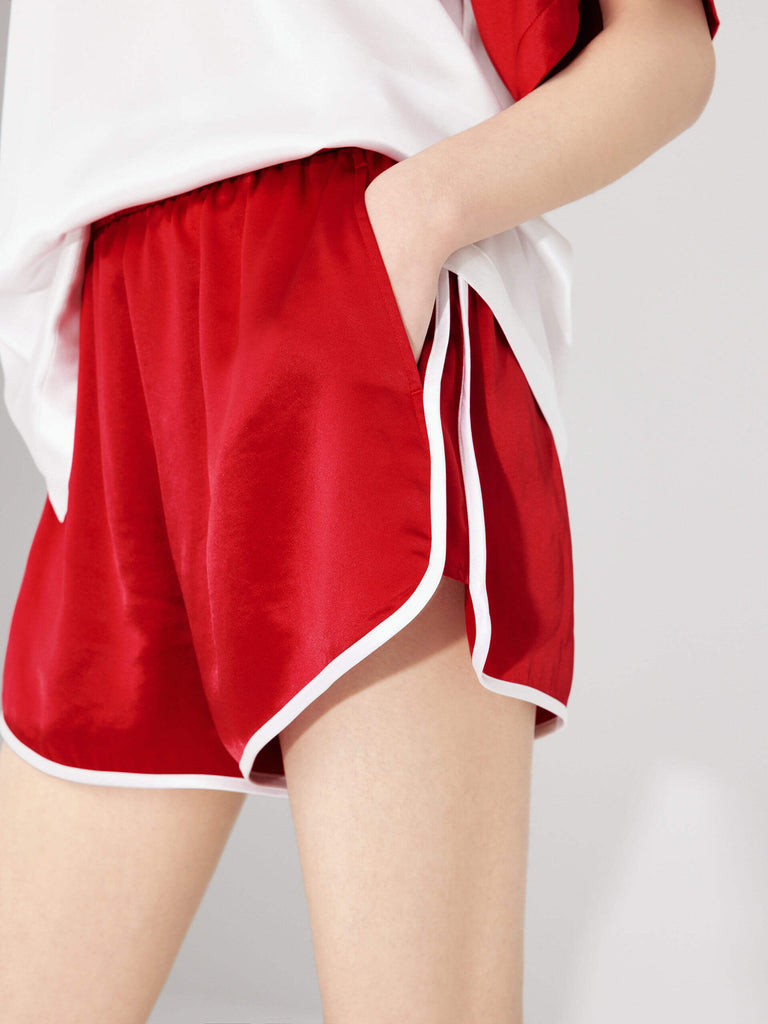 MO&Co. Women's Acetate Blend Contrast Track Shorts in Red feature a stylish athleisure silhouette, contrasting trim design, an elasticized waistband, and slant pockets--all constructed from a soft, smooth, and comfy acetate blend fabric.